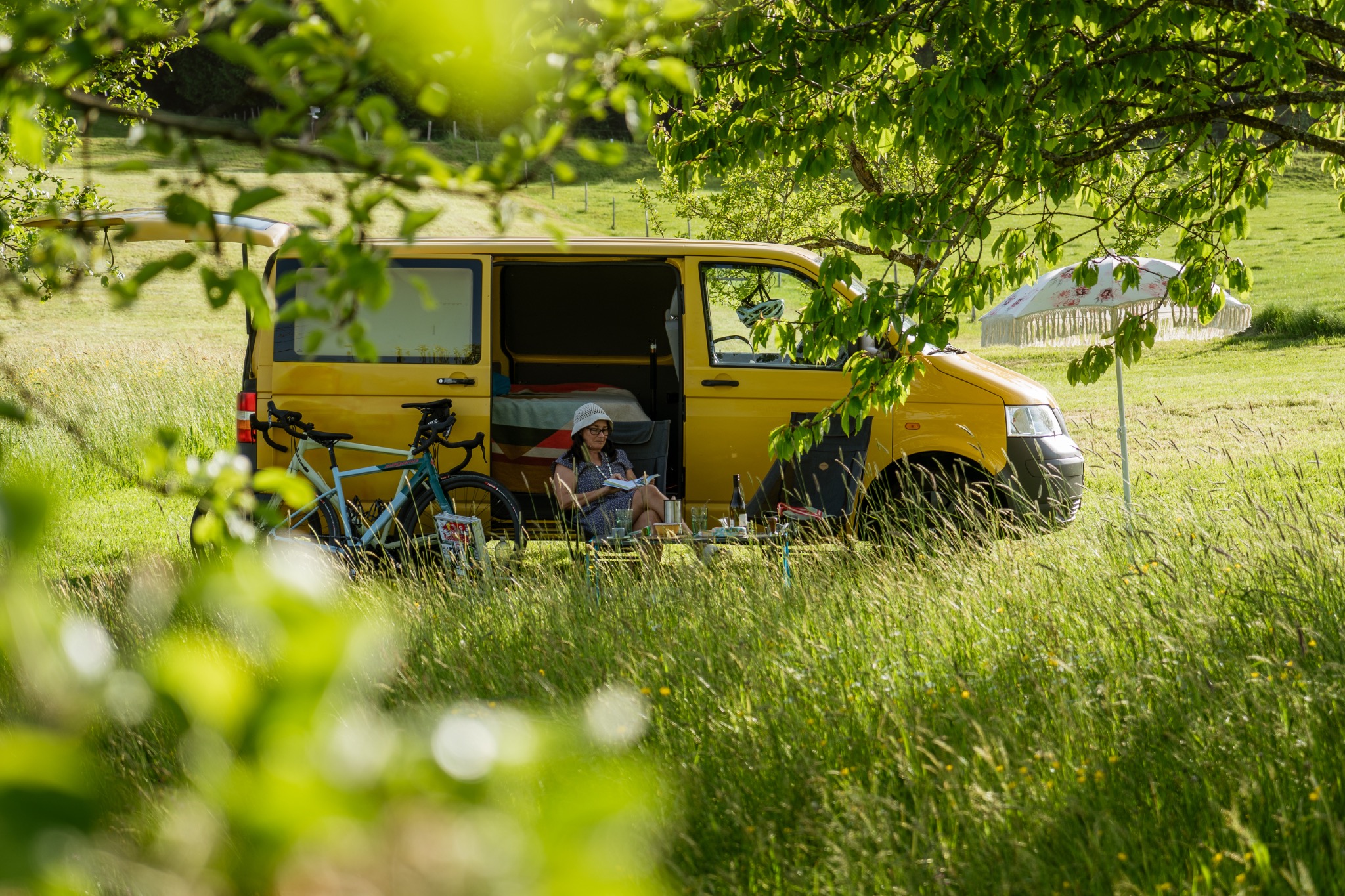 Unser gelber Campingbus zwischen Bäumen im Allgäu